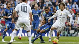 Gelandang Real Madrid, Luka Modric, berusaha melwati pemain Getafe, Wanderson, pada laga La Liga di Stadion Santiago Bernabeu, Spanyol, Sabtu (5/12/2015). (EPA/Zipi)