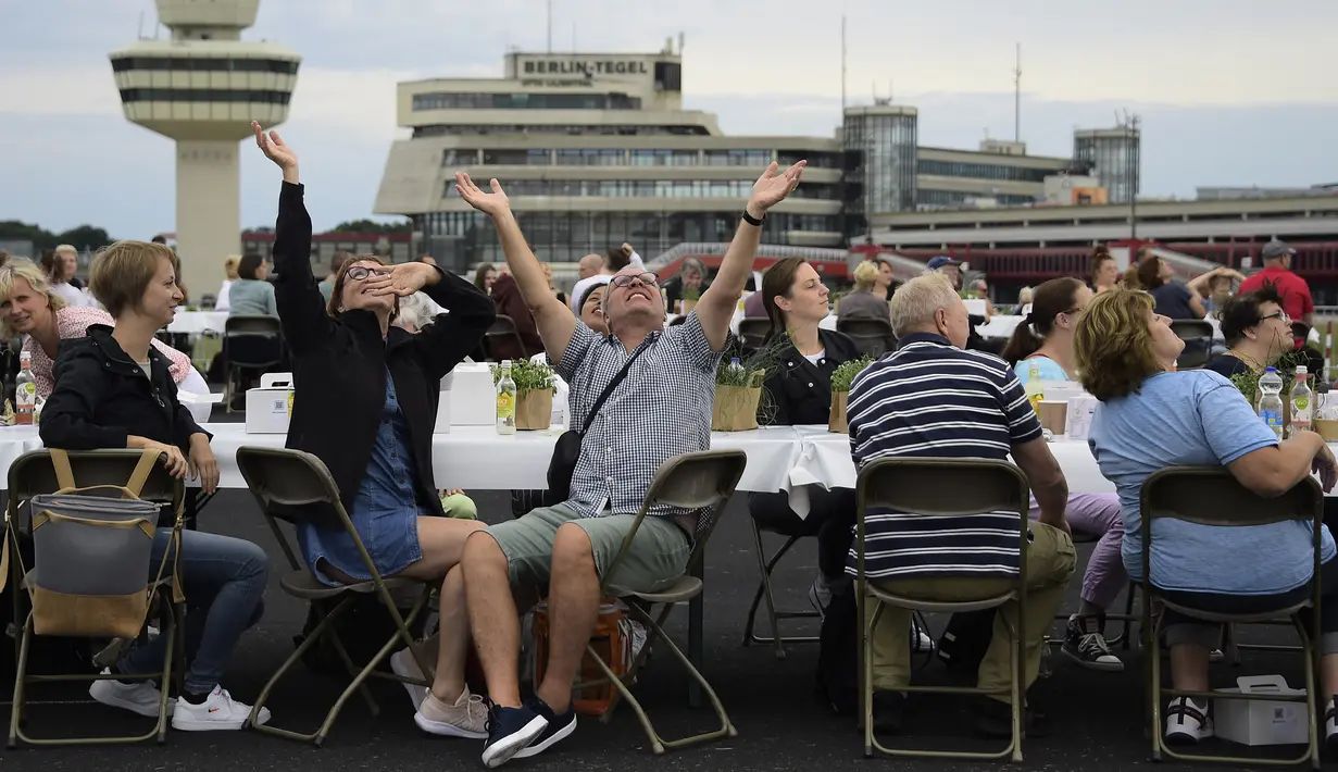 Orang-orang mengikuti acara“Berlin Freedom Dinner” di landasan pacu bekas bandara Tegel, Berlin pada 7 Agustus 2021. Acara yang dihadiri sekitar 3.000 warga tersebut untuk mengirim sinyal 'Berlin kembali!' setelah berbulan-bulan menghadapi pandemi COVID-19. (Tobias SCHWARZ/AFP)