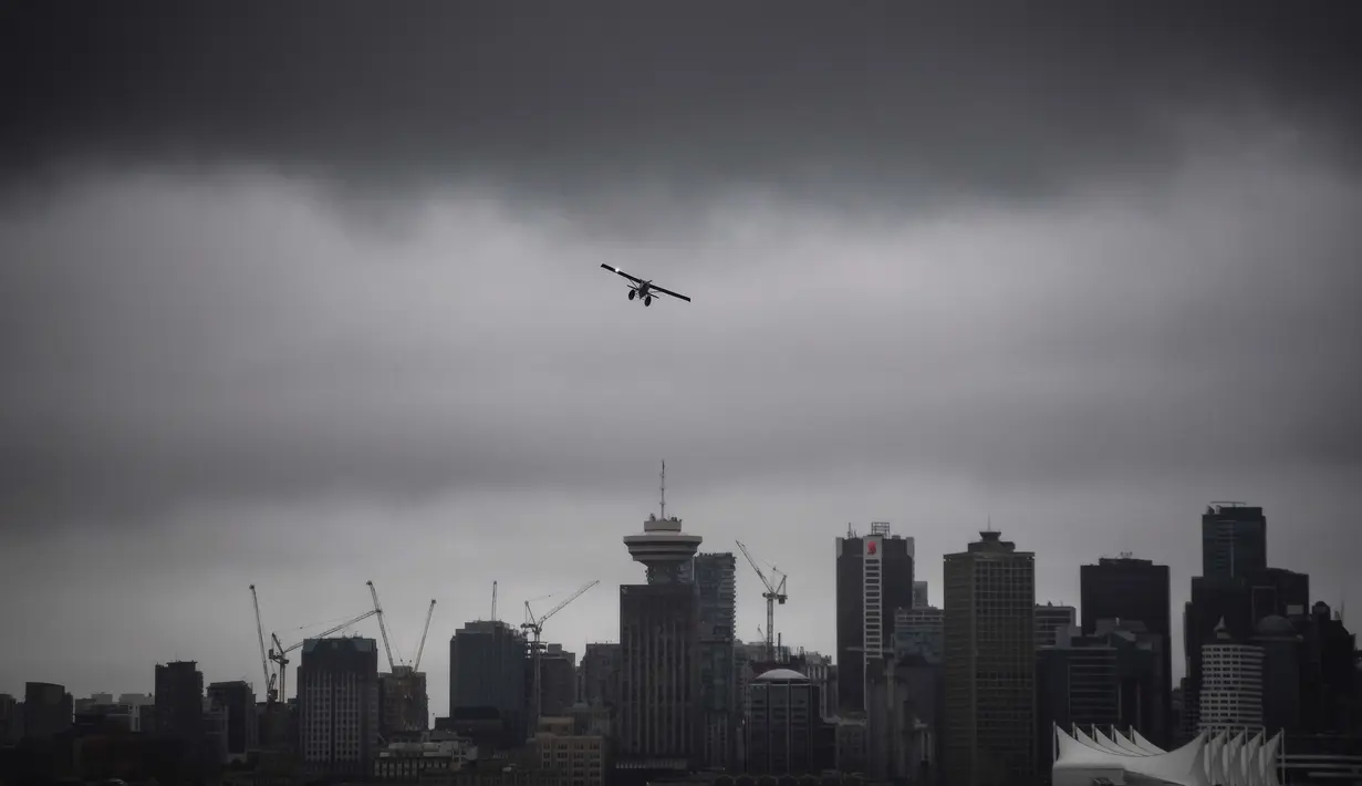 Sebuah pesawat amfibi lepas landas dari pelabuhan di bawah awan rendah di atas cakrawala pusat kota, di Vancouver, British Columbia, Kamis, (6/8/2020). (Darryl Dyck / The Canadian Press via AP)