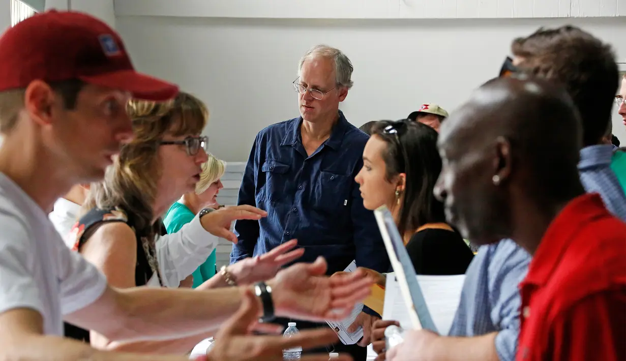 Bagian personalia (kiri) menjelaskan pekerjaan yang tersedia bagi para pelamar (kanan) Medical Marijuana Job Fair di McKeesport, Pennsylvania, Kamis (27/7). Dengan terobosan barunya, Job fair ini menarik perhatian ratusan pelamar. (AP/Gene J. Puskar)