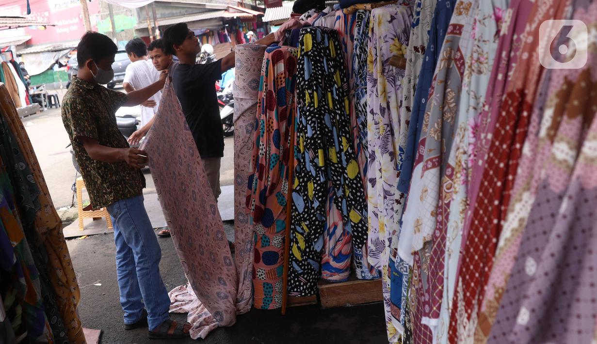 Calon pembeli memilih kain di Pasar Cipadu, Tangerang, Selasa (2/3/2021). Pandemi Covid-19 membuat industri tekstil dan pakaian jadi mengalami pertumbuhan negatif 8, 8% sepanjang 2020, bahkan pandemi membuat tenaga kerja di sektor industri tekstil berkurang hingga 13%. (Liputan6.com/Angga Yuniar)