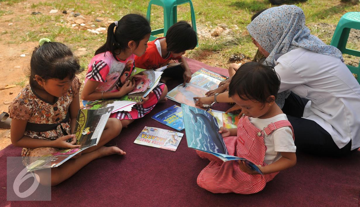 Sejumlah anak membaca buku di halaman Rusun Cipinang Besar Selatan, Jakarta, Rabu (27/4). Pemprov DKI Jakarta melengkapi fasilitas rusun tersebut berupa perpustakaan dan taman bermain anak. (Liputan6.com/Gempur M Surya)