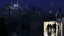 Pejalan kaki melintasi lorong di sebelah masjid Suleymaniye saat hujan salju di Istanbul, Turki, Sabtu (12/3/2022). Salju tebal menutupi Istanbul dan mengganggu lalu lintas udara menyebabkan transportasi laut serta darat terhenti, hingga memaksa penutupan sekolah. (AP Photo/Emrah Gurel)