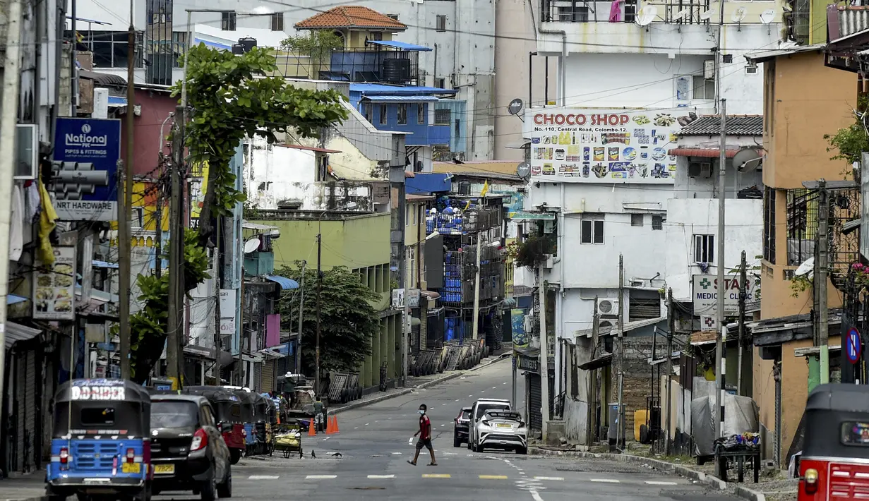 Seorang pria berjalan di sepanjang jalan yang sepi selama penguncian nasional untuk mengekang penyebaran Covid-19 di Kolombo, Sri Lanka (21/8/2021). Pemerintah Sri Lanka menerapkan penguncian ketat atau lockdown selama 10 hari ketika kasus Covid-19 kembali meningkat. (AFP/Ishara S. Kodikara)