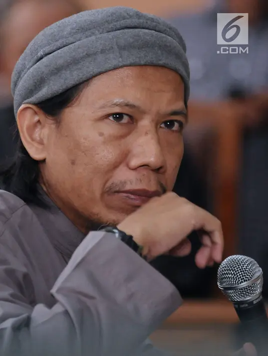 Terdakwa kasus terorisme, Aman Abdurrahman menyimak pembacaan tuntutan JPU di PN Jakarta Selatan, Jumat (18/5). Jaksa meyakini Aman Abdurrahman merupakan dalang serangan teror di Indonesia, antara lain bom Thamrin. (Liputan6.com/Helmi Fithriansyah)