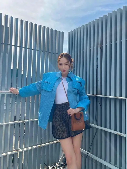 Tampil stylish dengan outfit kontras, kamu bisa memadukan jaket warna biru muda dengan t-shirt, dan short pants bermotif warna hitam-emas seperti OOTD ala Jessica Jung ini. (Instagram/Jessica.syj).