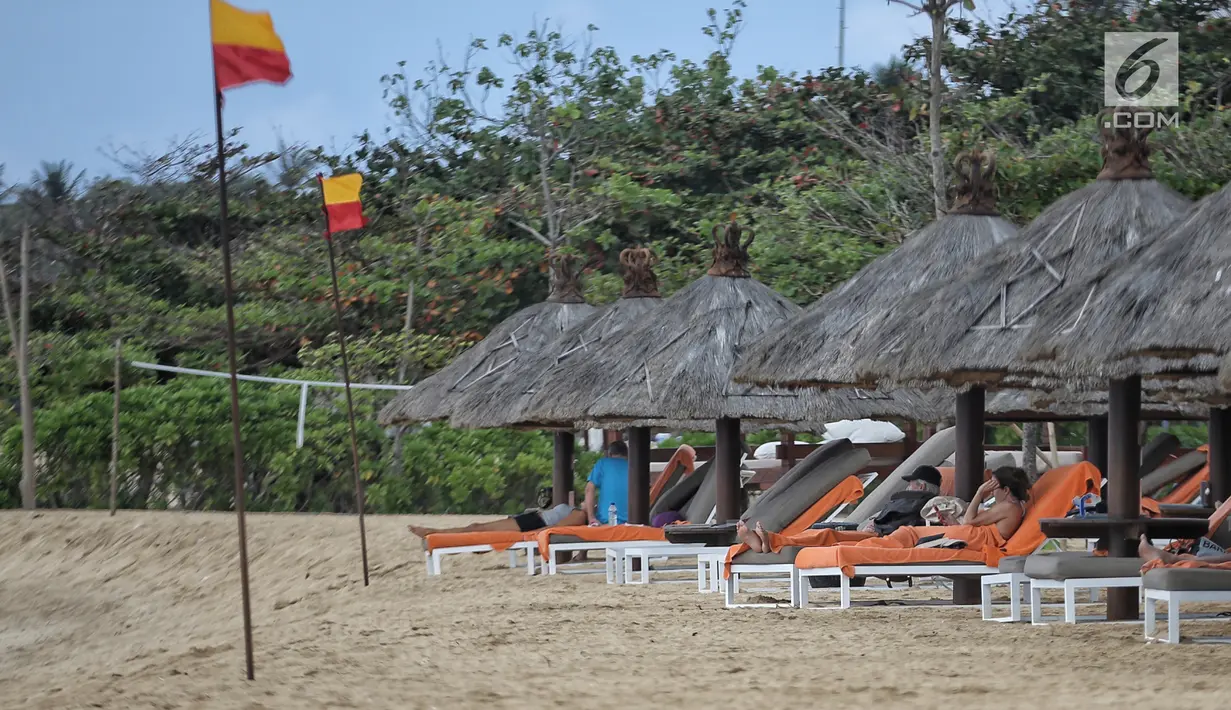 Sejumlah wisatawan asing berjemur di tepi Pantai Nusa Dua, Bali setelah gempa bumi, Senin (6/8). Aktivitas pantai Nusa Dua Bali masih ramai wisatawan asing setelah adanya gempa 7 pada skala richter yang berpusat di Lombok NTB. (Liputan6.com/Faizal Fanani)