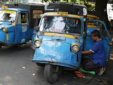 Sopir mengecek kondisi bemo di kawasan Bendungan Hilir, Jakarta, Kamis (22/10/2015). Maraknya perkembangan transportasi online di Ibu Kota membuat keberadaan angkutan bemo kian terpinggirkan akibat kalah bersaing. (Liputan6.com/Immanuel Antonius)