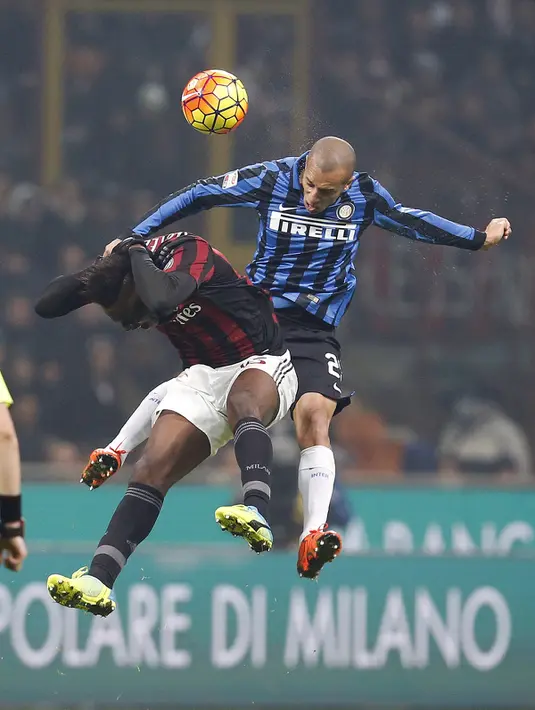 Penyerang AC Milan, Mario Balotelli (kiri) berebut bola udara dengan bek Inter Milan, Joao Miranda pada Liga Italia di Stadion San Siro, Milan (31/01/2016). AC Milan menang telak atas Inter Milan dengan skor 3-0. (REUTERS/Alessandro Garofalo)