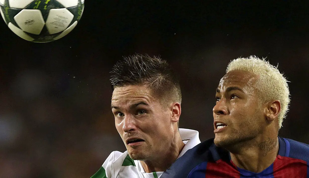 Penyerang Barcelona, Neymar, duel udara dengan bek Celtic, Mikael Lustig. Barca menguasai jalannya laga dengan catatan statistik penguasaan bola mencapai 65 persen. (EPA/Alberto Estevez)