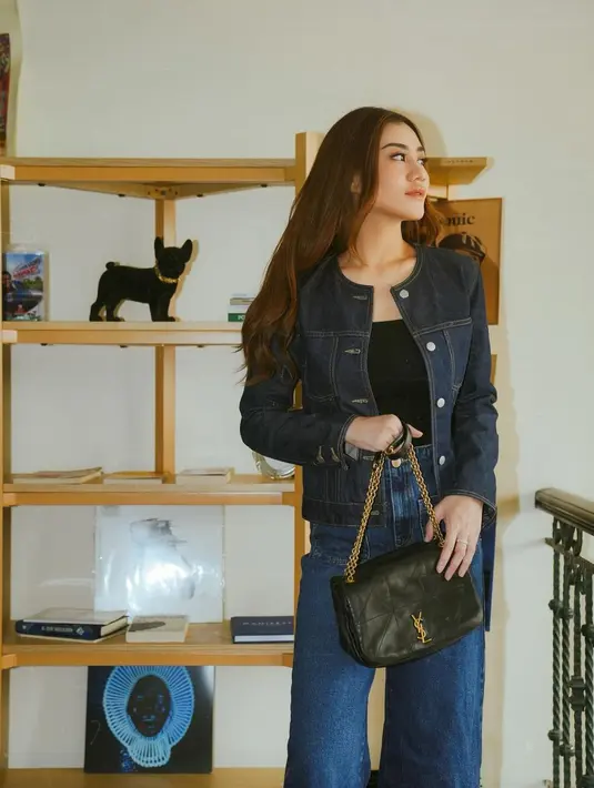 Jaket tersebut ia padukan bersama tanktop hitam. Sementara untuk bawahan, dipilih high waisted denim pants dengan detail saku di depan.