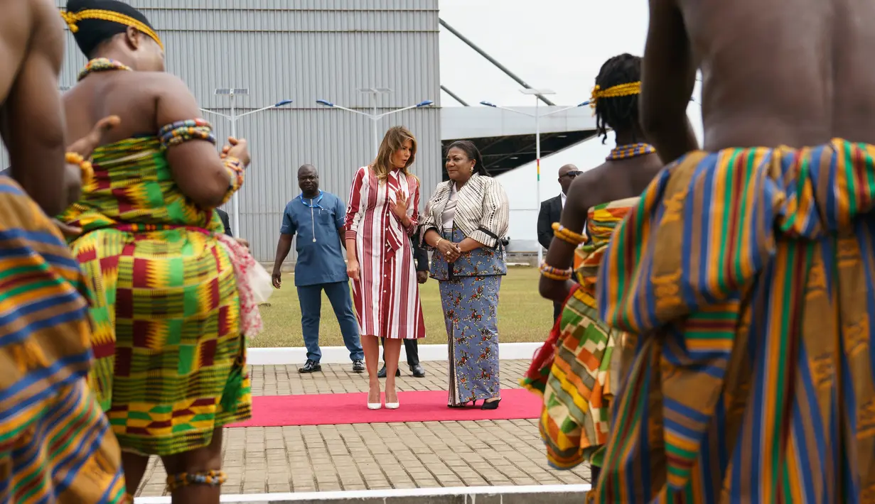 First Lady AS Melania Trump bersama Ibu Negara Ghana, Rebecca Akufo-Addo menyaksikan sekelompok penari tradisional saat upacara menyambut kedatangannya di Bandara Internasional Kotoka, Accra, Selasa (2/10). (AP/Carolyn Kaster)