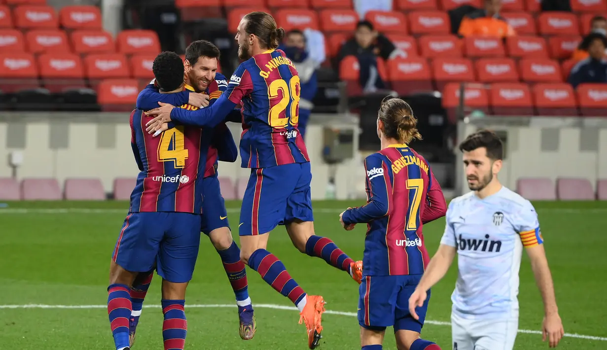 Para pemain Barcelona merayakan gol kedua yang dicetak bek Ronald Araujo (kiri) ke gawang Valencia dalam laga lanjutan Liga Spanyol 2020/21 di Camp Nou Stadium, Barcelona, Sabtu (19/12/2020). Barcelona bermain imbang 2-2 dengan Valencia. (AFP/Lluis Gene)