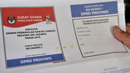 Petugas menunjukkan surat suara yang terkena bercak noda di Gedung Logistik KPU Kota Jakarta Pusat, Salemba, Jakarta, Selasa (5/3). Sebanyak 60 persen surat suara rusak akibat terpotong atau tidak simetris dan bercak noda. (merdeka.com/Iqbal Nugroho)