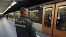 Petugas keamanan berjaga saat sebuah kereta tiba di Stasiun Metro Maelbeek di Brussels, Ibu Kota Belgia, Senin (25/4). Stasiun kereta metro tersebut akhirnya dibuka kembali setelah serangan bom 22 Maret 2016 lalu yang menewaskan 35 orang. (JOHN Thys /AFP)