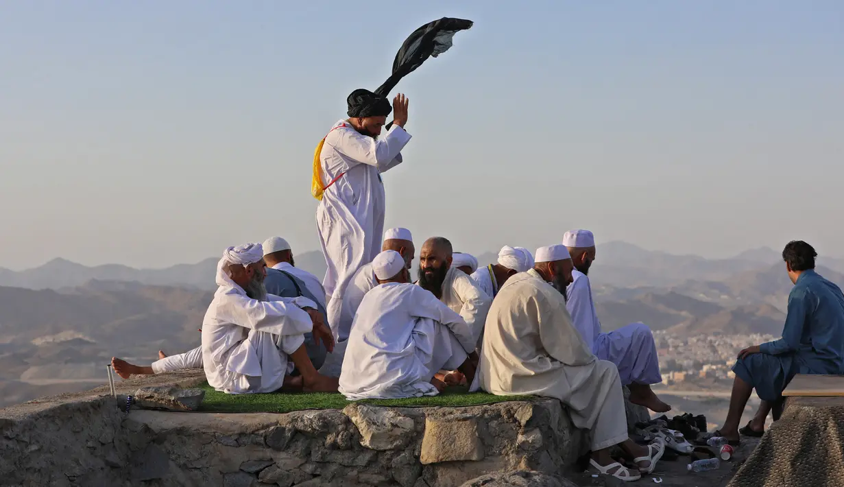 Peziarah muslim berfoto di Jabal al-Noor atau Gunung Cahaya yang menghadap ke Kota Suci Mekkah, Arab Saudi, 5 Juli 2022. Satu juta orang, termasuk 850 ribu dari luar negeri, diizinkan untuk berpartisipasi dalam haji tahun ini setelah dua tahun terakhir jumlahnya dikurangi secara drastis karena pandemi virus corona COVID-19. (Christina ASSI/AFP)