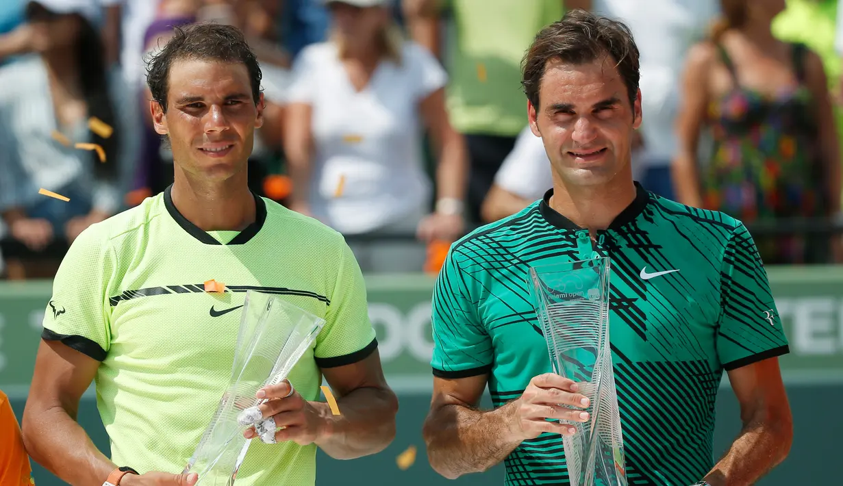 Roger Federer (kanan) dan Rafael Nadal berpose dengan trofinya di Crandon Park, Florida (2/4). Bagi Federer, ini adalah titel ketiganya di Miami atau yang pertama dalam 11 tahun usai memenanginya di 2005 dan 2006. (AP Photo/Wilfredo Lee)