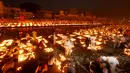 Orang-orang menyalakan lampu di tepi sungai Saryu di Ayodhya, India, Rabu (3/11/2021). Lebih dari 900.000 lampu minyak dinyalakan dan terus menyala selama 45 menit saat kota Ayodhya mempertahankan Rekor Dunia Guinness sebagai bagian dari perayaan festival Diwali. (AP Photo/Rajesh Kumar Singh)