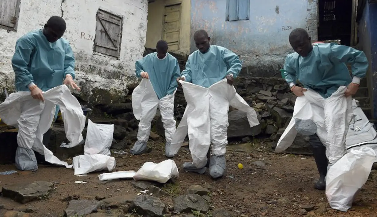 Petugas medis Croix Rouge LSM mengenakan pakaian pelindung sebelum mengevakuasi mayat korban Ebola di Monrovia, 29 September 2014. Dari empat negara di Afrika Barat, Liberia menjadi negara yang paling parah terkena wabah Ebola. (AFP PHOTO/PASCAL GUYOT)