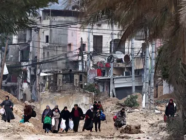 Warga Palestina meninggalkan rumah mereka untuk menyelamatkan diri selama serangan tentara Israel di kamp pengungsi Nur Shams dekat Tulkarem di Tepi Barat yang diduduki pada 11 Februari 2025. (Zain JAAFAR/AFP)