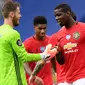 Kiper Manchester United, David de Gea berselebrasi dengan gelandang timnya, Paul Pogba pada akhir partai pamungkas Liga Inggris menghadapi Leicester City di Stadion King Power, Minggu (26/7/2020). MU lolos ke Liga Champions musim depan usai mengalahkan Leicester City 2-0. (Michael Regan/Pool via AP)