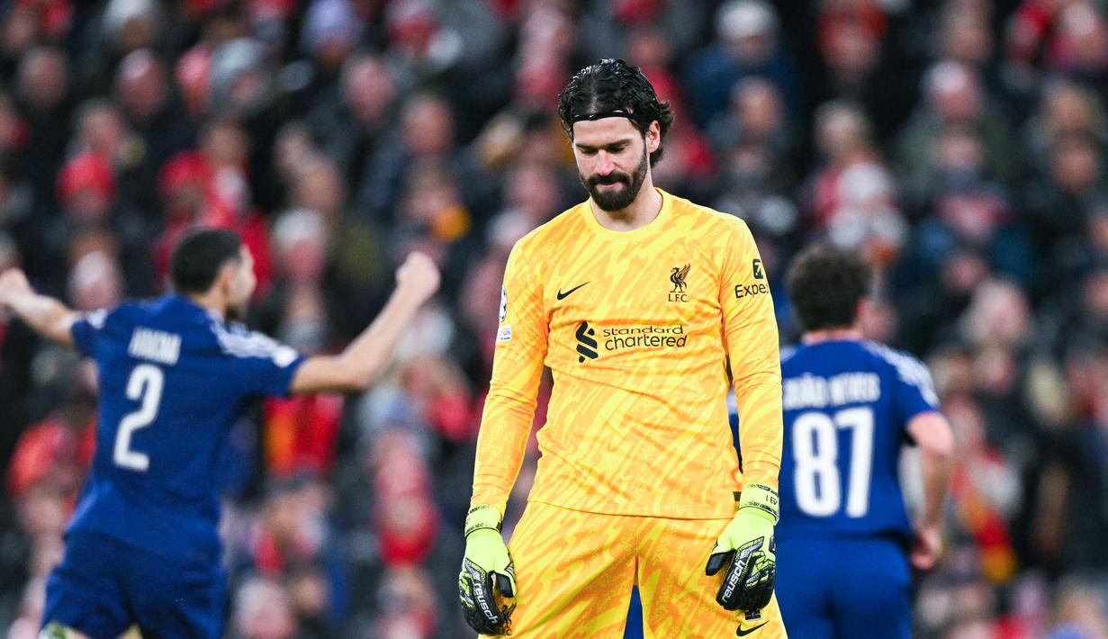 Kiper Liverpool, Alisson Becker, tampak kecewa setelah ditaklukkan PSG lewat adu penalti 0-1 (1-4) dalam laga leg kedua 16 besar Liga Champions 2024/2025 yang digelar di Anfield, Rabu (12/3/2025) dini hari WIB. (AFP/Oli Scarff)