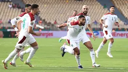 Penyerang Maroko Sofiane Boufal (kanan) melakukan selebrasi usai mencetak gol tendangan penalti ke gawang Mesir pada pertandingan perempat final Piala Afrika (CAN) 2021 di Stade Ahmadou Ahidjo di Yaounde (30/1/2022). Mesir menang atas Maroko 2-1. (AFP/Kenzo Tribouillard)