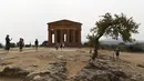Turis saat mengunjungi Lembah Kuil selama gelombang panas di dekat Agrigento, Sisilia, Italia (11/8/2021). Gelombang panas yang berkelanjutan akan berlangsung hingga akhir pekan dengan suhu diperkirakan mencapai lebih dari 40 derajat Celcius di banyak bagian dari Italia. (AP Photo/Salvatore Cavalli)