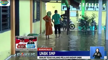 Demi lancarnya UNBK, guru memasang beton di pintu ruang kelas pada Rabu malam saat hujan deras mengguyur.