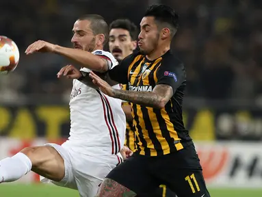 Pemain AC Milan, Leonardo Bonucci berebut bola dengan pemain AEK Athens, Sergio Araujo dalam laga lanjutan Grup D Liga Europa di Stadion Athens Olympic, Jumat (3/11). Tandang ke markas AEK, Milan hanya meraih hasil imbang 0-0. (AP/Petros Giannakouris)