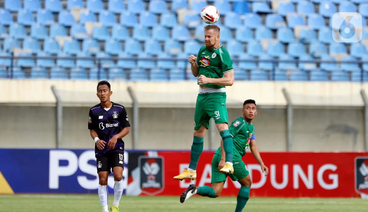 Pemain PS Sleman, Maslac Mario (tengah) mennghalau bola diudara dalam pertandingan Babak Penyisihan Grup C Piala Menpora 2021 melawan PS Sleman di Stadion Si Jalak Harupat, Bandung, Kamis (1/4/2021). PSS Sleman berhasil menang 1-0 atas Persik Kediri. (Bola.com/Ikhwan Yanuar)