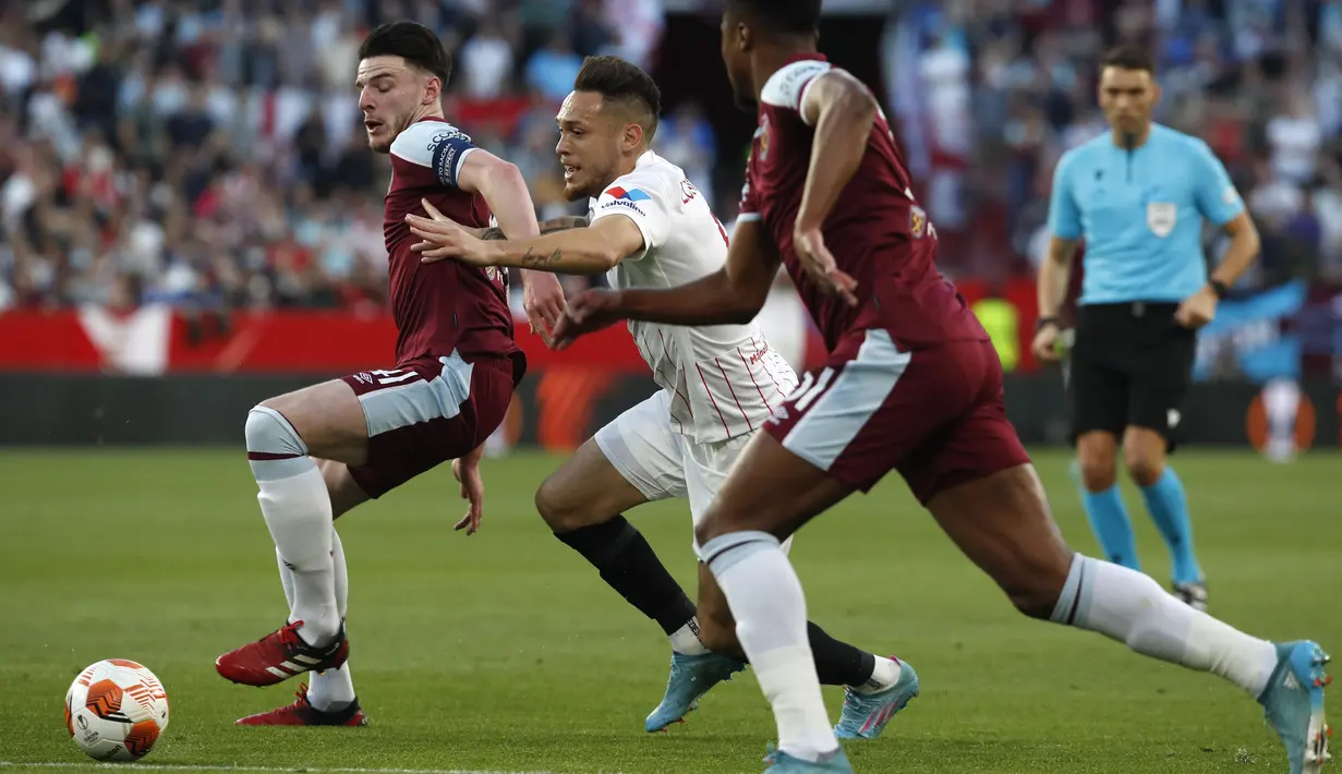 Penyerang Sevilla, Lucas Ocampos berebut bola dengan pemain West Ham, Declan Rice pada pertandingan leg pertama babak 16 besar Liga Europa di stadion Ramon Sanchez-Pizjuan, Spanyol, Jumat (11/3/2022). Sevilla menang atas West Ham 1-0. (AP Photo/Angel Fernandez)