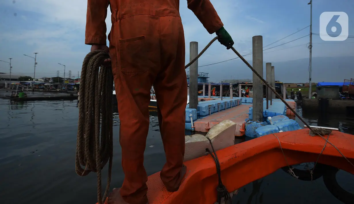 Petugas dari Dinas Lingkungan Hidup DKI Jakarta mengumpulkan sampah di Pelabuhan Kali Adem, Muara Angke, Jakarta, Rabu (6/1/2021). Dalam sehari, sampah pesisir Teluk Jakarta Utara bisa terangkut sekitar 7 kubik sampah plastik yang terbawa dari sungai maupun arus laut. (merdeka.com/Imam Buhori)