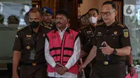 Menteri Komunikasi dan Informatika (Menkominfo) Johnny G. Plate mengenakan rompi pink dan tangan diborgol saat keluar dari Gedung Bundar, Kejaksaan Agung, Jakarta, Rabu (17/5/2023). (Liputan6.com/Faizal Fanani)