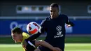 Penyerang Prancis Kylian Mbappe (kanan) berebut bola dengan rekan setimnya Bejamin Pavard saat sesi latihan sebagai bagian dari persiapan tim untuk UEFA Nations League 2022-2023 di Clairefontaine-en-Yvelines, Senin (30/5/2022). Prancis yang menjuarai Nations League tahun lalu akan menjamu Denmark di Stade de France pada Sabtu, 4 Juni 2022 dini hari WIB. (FRANCK FIFE/AFP)