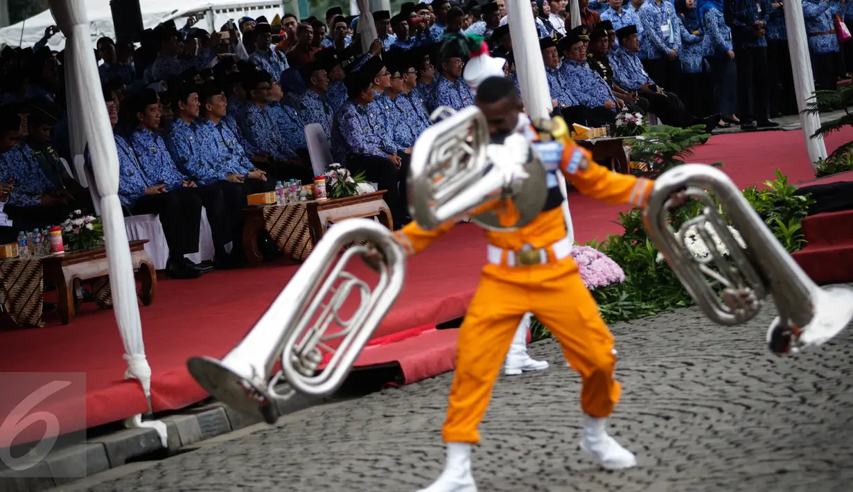 Presiden Jokowi melihat parade marching band dari IPDN pada upacara peringatan HUT Korps Pegawai Republik Indonesia (Korpri) ke 45 di Silang Monas, Jakarta,  Selasa (29/11). Presiden Jokowi bertindak menjadi Inspektur Upacara. (Liputan6.com/Faizal Fanani)
