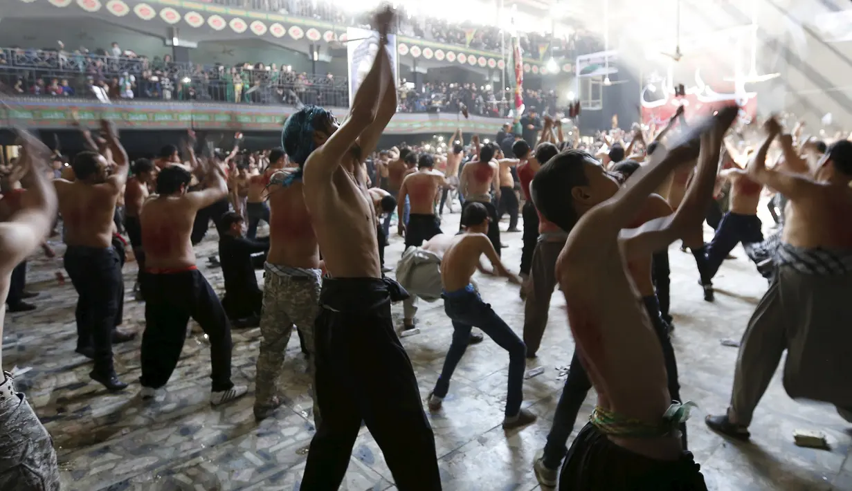 Sejumlah pria mencambuk dirinya sendiri dengan rantai selama peringatan Asyura di Kabul, Afghanistan, Rabu (21/10/2015).  Acara ini dirayakan oleh warga Islam Syiah di Afghanistan. (REUTERS/Mohammad Ismail)