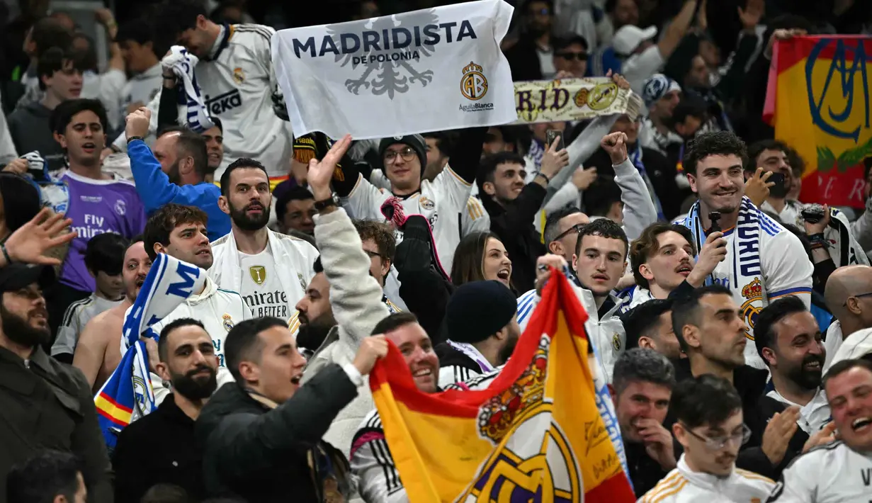 Los Blancos menutup pertandingan dengan agregat meyakinkan 5-1 atas Manchester City. Tampak dalam foto, penggemar Madrid bersorak mendukung tim mereka selama pertandingan leg kedua 16 besar Liga Champions 2025/2026 melawan Manchester City di Etihad Stadium, barat laut Inggris, pada Selasa 17 Maret 2026 waktu setempat atau Rabu (18/3) dini hari WIB. (Paul ELLIS/AFP)