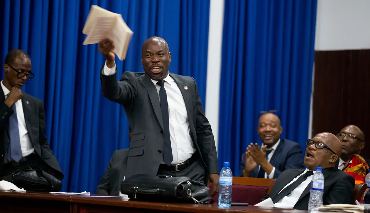 Anggota parlemen Jean Marcel Lumérant berbicara mendukung pemakzulan terhadap Presiden Haiti Jovenel Moise saat sidang di Port-au-Prince, Haiti, Rabu (21/8/2019). Sidang diwarnai dengan genangan air hujan pada lantai gedung parlemen karena atap yang bocor. (AP Photo/Dieu Nalio Chery)