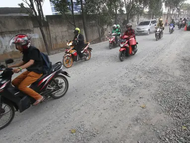 Kendaraan melintasi Jalan TB Simatupang yang berdebu akibat peninggian jalan di Jakarta, Kamis (20/10). Kondisi tersebut menyebabkan pengendara harus lebih berhati-hati karena jarak pandang yang terbatas. (Liputan6.com/Immanuel Antonius) 