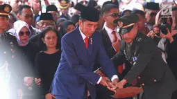 Presiden RI Joko Widodo atau Jokowi saat menimbun tanah ke liang lahat almarhumah Ani Yudhoyono di TMP Kalibata, Jakarta, Minggu (2/6/2019). Ani Yudhoyono meninggal dunia di National University Hospital Singapura pada 1 Juni 2019 karena kanker darah. (Fimela.com/Deki Prayoga)