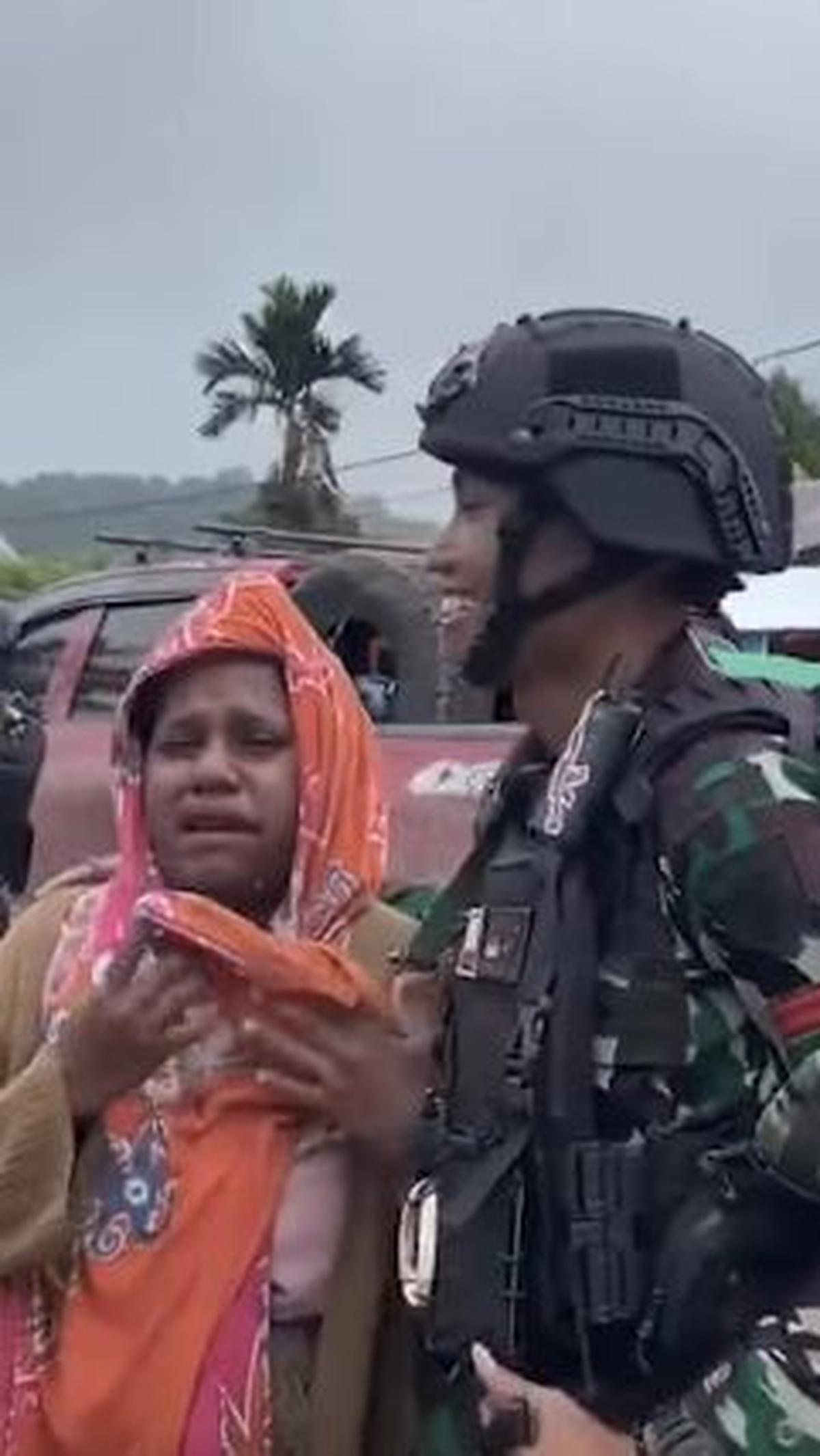 "Aku sedih sekali ini," ujar wanita ini berdiri di samping prajurit TNI sembari menangis sesengukan.<br>