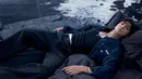 Look berikutnya menghadirkan nuansa misterius lewat outfit serba gelap: tank top hitam, jaket denim biru tua, dan jeans hitam. Pose bersandar dengan mata terpejam menciptakan kesan sensual yang lebih emosional, memperlihatkan sisi artistik Jung Kook. [Dok/Calvin Klein].