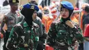 Dua aparat TNI wanita berjaga saat Hari Buruh Sedunia di depan Istana Negara, Jakarta, Selasa (1/5). Memperingati Hari Buruh 2018, ribuan buruh mulai memadati Istana Kepresidenan, Jakarta Pusat. (Liputan6.com/Johan Tallo)