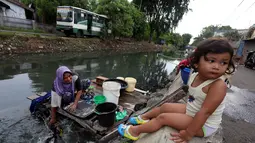 Seorang wanita memanfaatkan aliran Kali Maja untuk mencuci pakaian, Jakarta, Selasa (7/11). Warga dikawasan tersebut terpaksa memanfaatkan air kali untuk mencuci dikarenakan air di rumah mereka keruh dan asin. (Liputan6.com/JohanTallo)