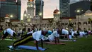  Sejumlah orang melakukan gerakan yoga di ikon bangunan Sultan Abdul Samad, Kuala Lumpur, Malaysia, (21/6). Sejumlah negara di dunia sedang merayakan Hari Yoga Dunia yang jatuh pada tanggal 21 Juni. (MANAN VATSYAYANA / AFP)