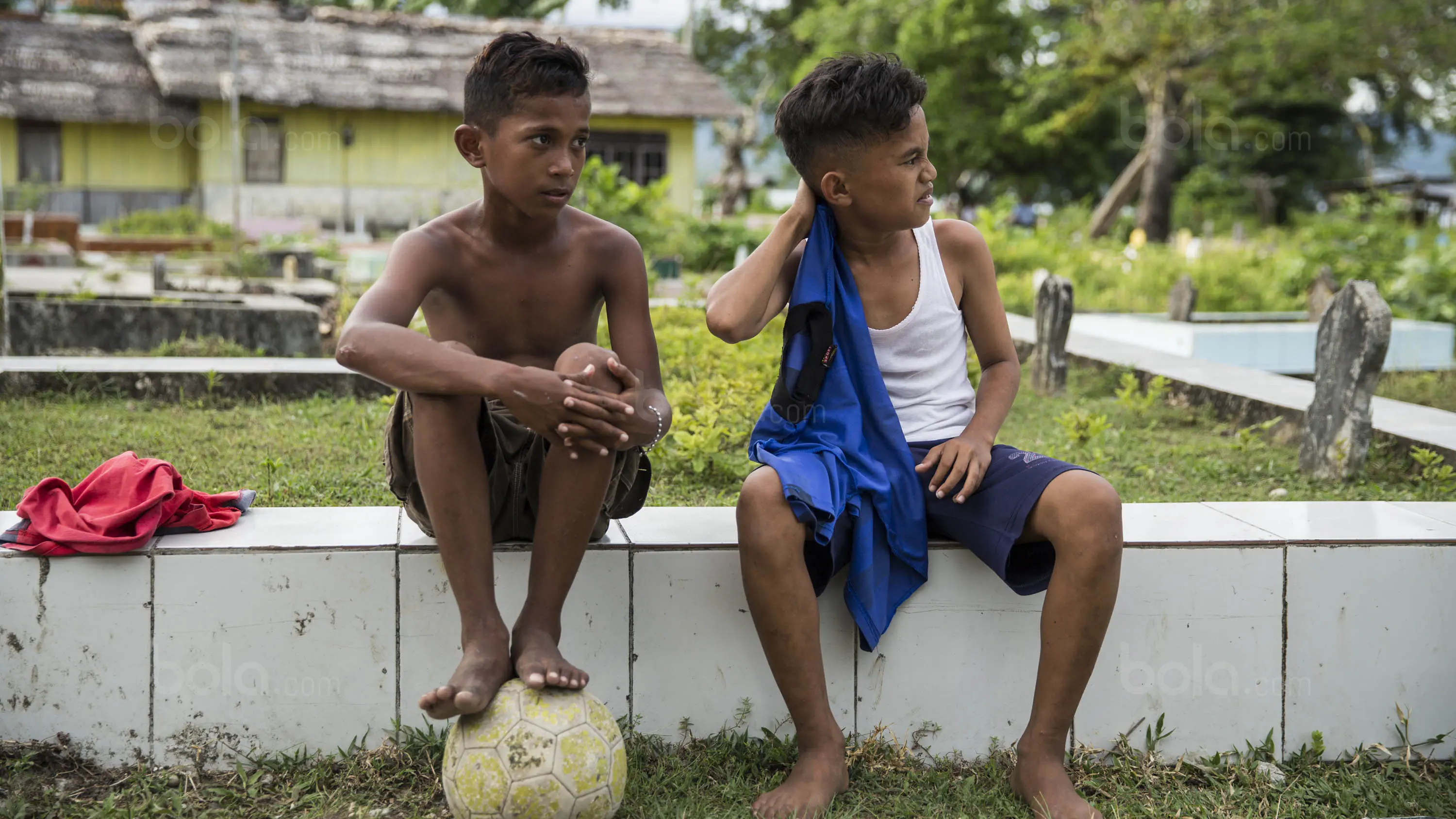 Pesepak bola SSB Tulehu Putra, Saleh Al'Ayubi Pary beristirahat usai latihan disekitar makam leluhur. (Bola.com/Vitalis Yogi Trisna)