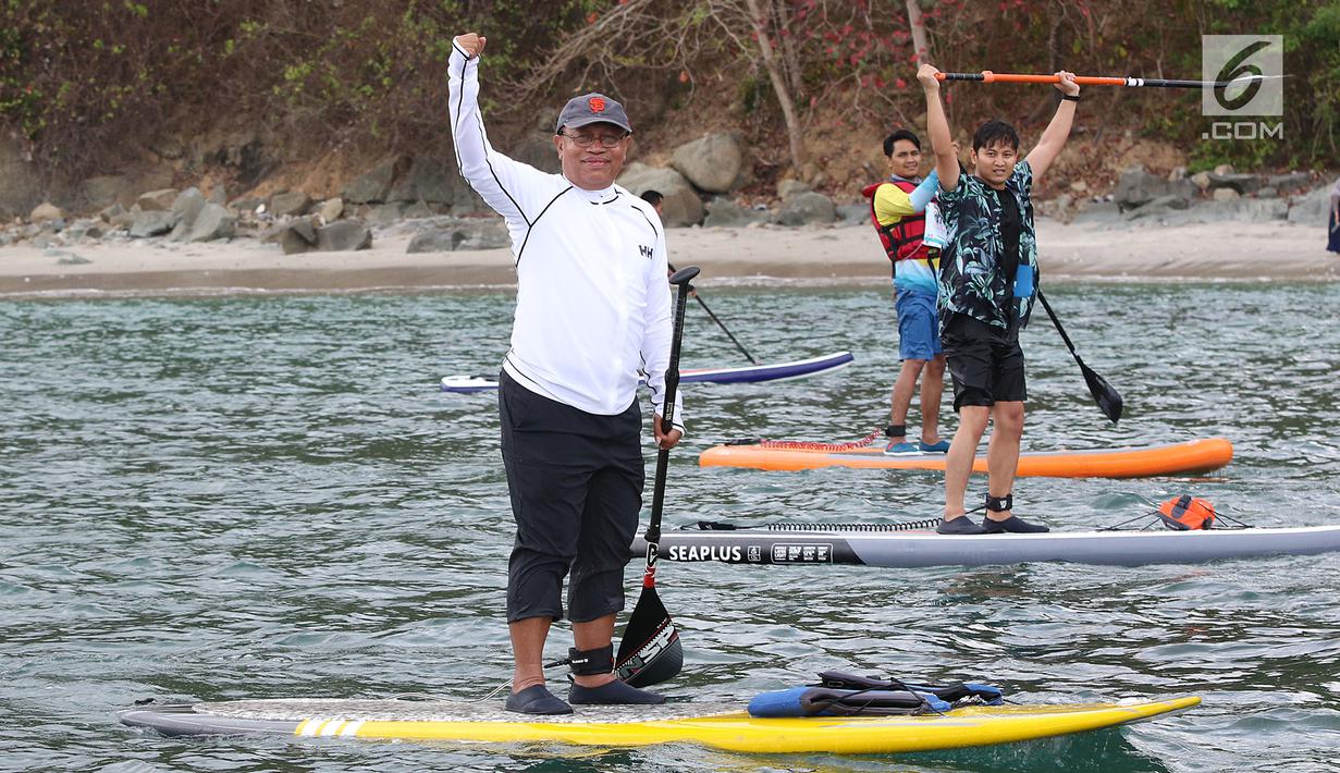 Direktur Utama Ketenagakerjaan, Agus Susanto dan Bupati Trenggalek, Mochammad Nur Arifin olah raga  Stand Up Paddle di Pantai Mutiara, Trenggalek, Jawa Timur, Sabtu (7/9/2019). (Liputan6.com/Herman Zakharia)