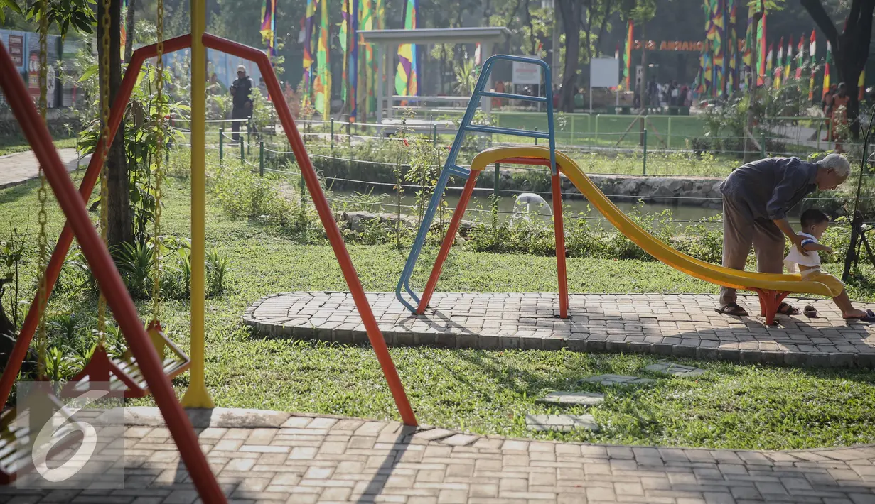 Seorang bapak mengajak bermain anaknya di RPTA Kelurahan Pejagalan, Kecamatan Penjaringan, Jakarta (6/4). Salah satu fungsi RPTRA adalah tempat berkumpul untuk warga. (Liputan6.com/Faizal Fanani)
