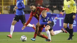 Pemain Estonia, Hindrek Ojamaa berebut bola dengan bek Belgia, Jason Denayer pada pertandingan pertandingan grup E kualifikasi Piala Dunia 2022 di stadion King Baudouin di Brussels, Minggu (14/11/2021). Belgia menjadi wakil keempat Eropa yang menyegel tempat di Piala Dunia 2022. (AP Photo/Olivier Ma